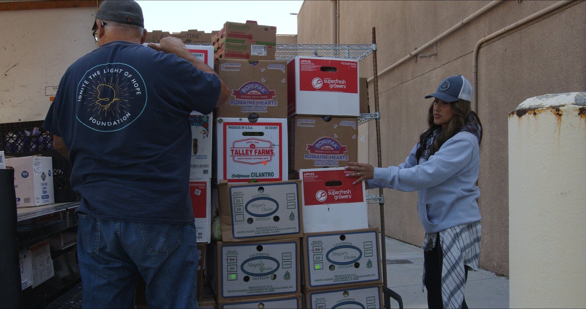 Lorraine Aceves loads boxes of fresh produce with a volunteer