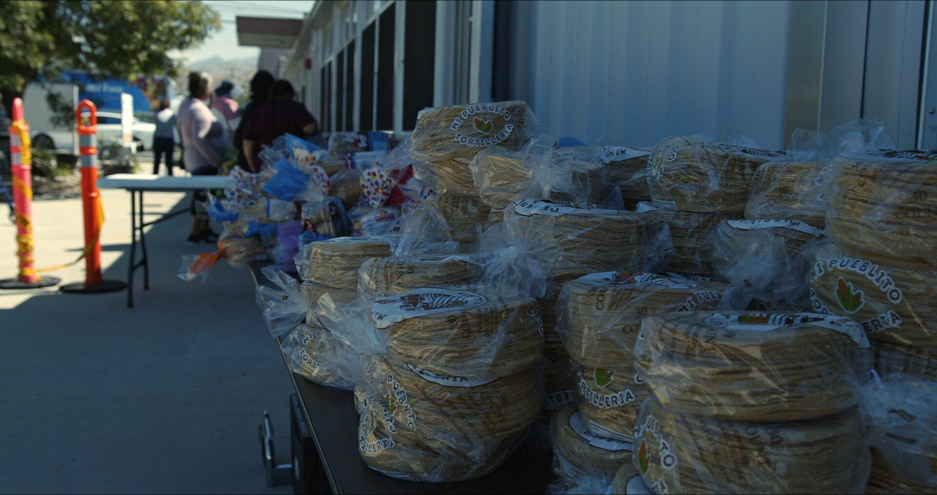 Stacks of tortillas bagged and ready on a distribution table